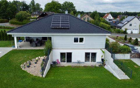Dänisches Holzblockhaus mit Souterrain-Keller und bodentiefen Fenstern, Solaranlage und überdachter Terrasse im Garten